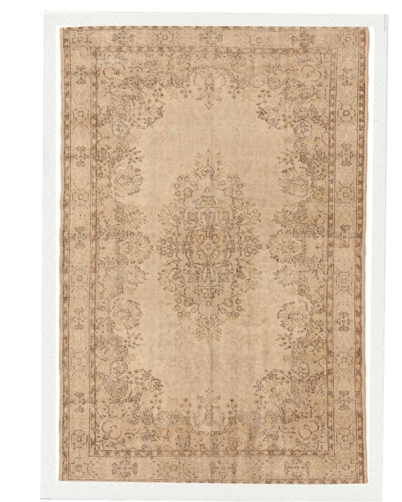 Upcycled antique rug reinterpreted with a soft neutral palette, preserving heritage motifs within a contemporary interior context